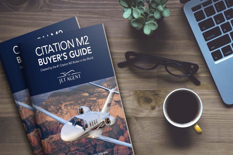 Citation M2 Buyer's Guide for new aircraft acquisitions - new jet buyers - cover of book on table with coffee and laptop - The Jet Agent logo